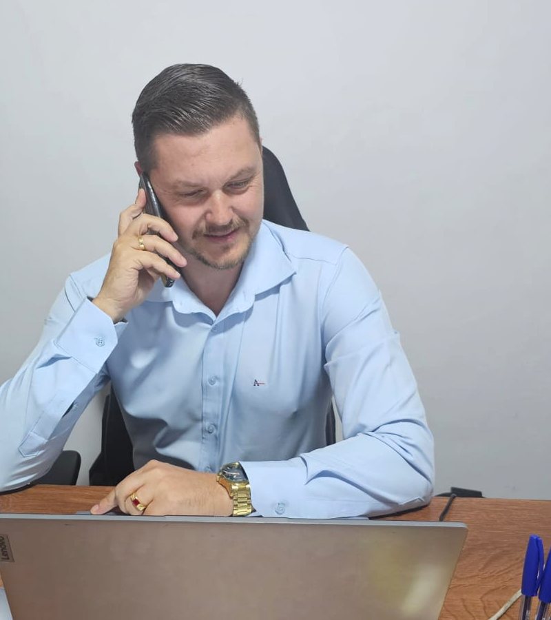 Dr. Marcos Viveiro ao telefone, à mesa do escritório